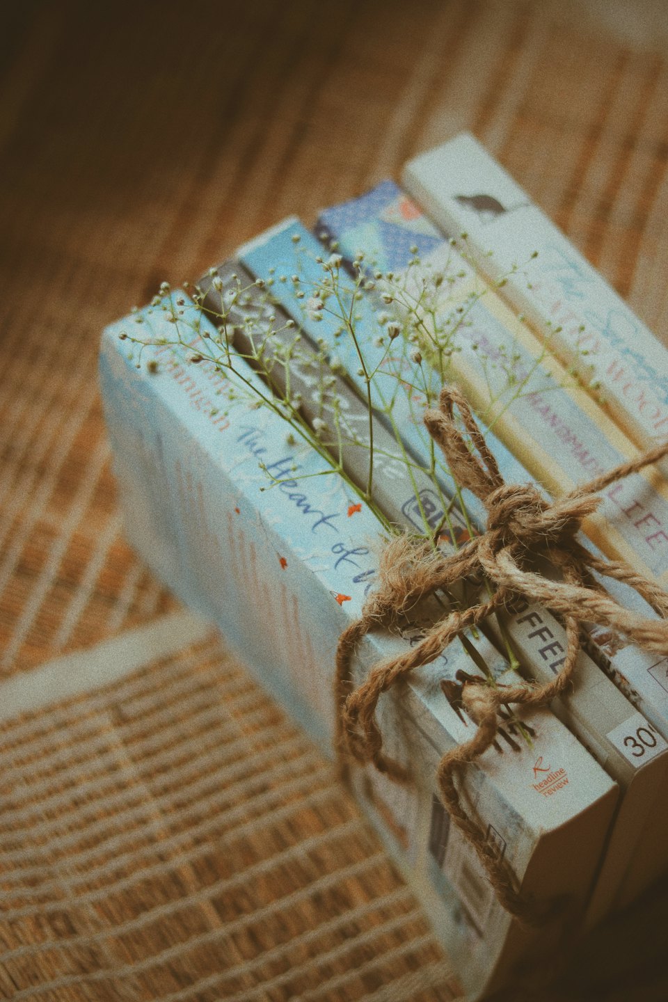 Paperback books tied with twine and baby's breath flowers.