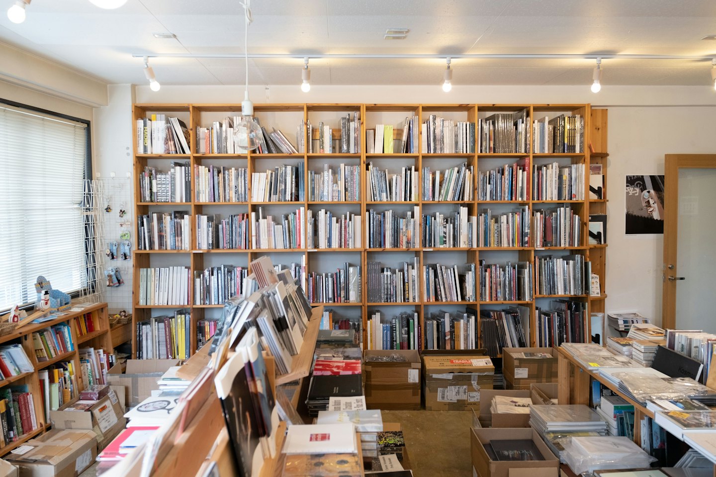 Wooden bookshelves packed with books fill an independent bookstore.