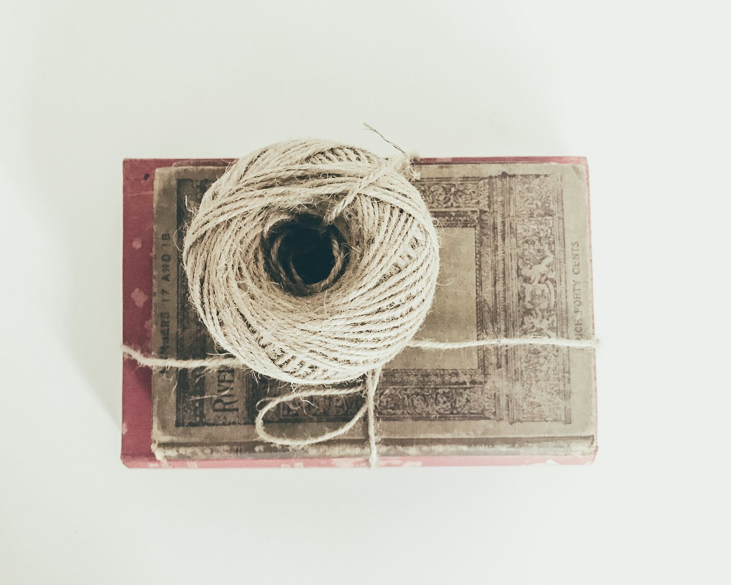 Two vintage books tied with twine and a ball of string.